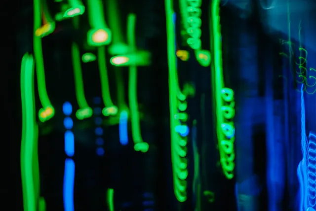 Grün leuchtende Netzwerkkabel im Dunkeln.